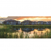 A row of homes in Oak Bluff, Man., is reflected in a naturalised storm water system constructed by DUC’s Native Plant Solutions. Growing in popularity, these wetland-like systems offer attractive, sustainable green infrastructure solutions that support biodiversity and connect residents with nature.